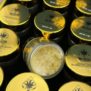 Ace Ultra Crumble 1oz concentrate box packaging and clear storage jar displaying golden wax 28g