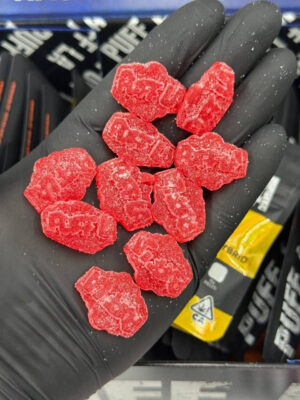 Puff LA Edibles 1000mg THC Cluster Gummies packaging display showing Strawberry Blueberry and Grape flavors
