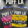 Puff LA Edibles 1000mg THC Cluster Gummies packaging display showing Strawberry Blueberry and Grape flavors